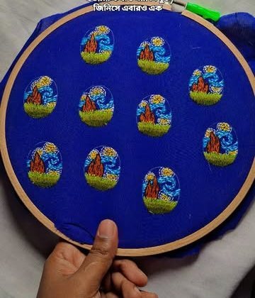 Tiny embroidered landscapes on a blue fabric hoop, held by the maker